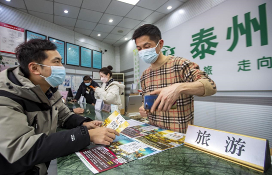 A man consults a travel agency in Taizhou, east China's Jiangsu province about outbound group tours, Feb. 9, 2023. (Photo by Tang Dehong/People's Daily Online)