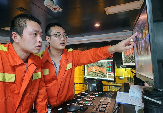 Staff members of Chinese dredger Tian Kun Hao check the operation of the vessel in the cabin. (Photo by Guan Kejiang/People's Daily) 