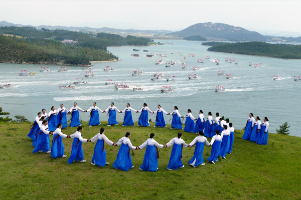 Women Jindo County perform the famed traditional Ganggangsullae ring-dance clad in white Jogori jacket and blue Chima skirts. Historical records show that the ring dance made the Japanese invasion ships retreat because of the endless number of dancing womn circling around the hill during the Imjin Oeran (Japanese invasion of Korea of 1592-1598).