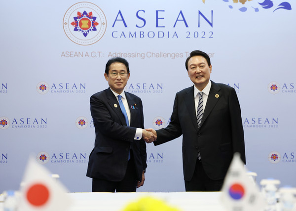 President Yoon Suk-yeol (right) shakes hands with Japanese Prime Minister Fumio Kishida at the Korea-Japan summit held at a hotel in Phnom Penh, Cambodia on Nov. 13 in 2022.