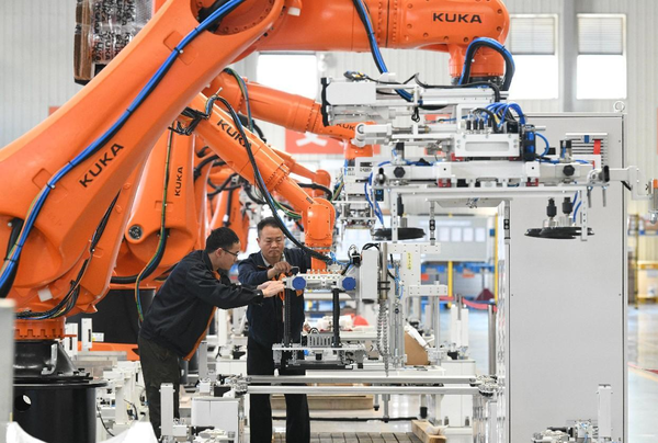 Workers debug robotic arms in a workshop of an intelligent equipment enterprise in Ningde, east China's Fujian province, March 8, 2023. (Photo by Wang Wangwang/People's Daily)