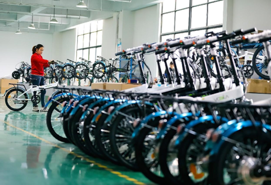 An employee works at a foldable electric bicycle packaging workshop in Jiujiang city, east China's Jiangxi province, to meet the deadlines for export orders, March 8, 2023. (Photo by Zhang Yu/People's Daily Online)