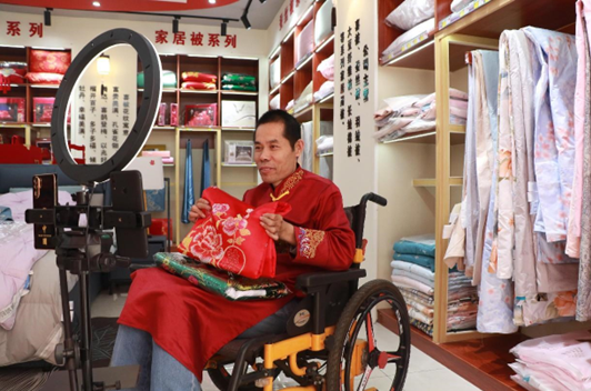 A man with mobility impairments sells products via livestreaming in Pangjia township, Binzhou, east China's Shandong province. (Photo by Shao Qiang/People's Daily Online)