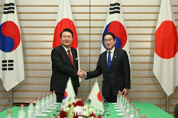 President Yoon and Prime Minister Kishida (left and right, respectively) shake hands with each other at an extended summit meeting between the countries on March 16.
