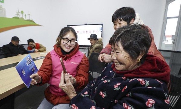 Volunteers help senior citizens learn to use smartphone in a residential community in Huai'an city, east China's Jiangsu province. (Photo by Zhao Qirui/People's Daily Online)