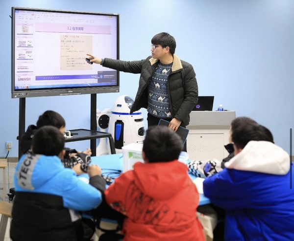 A teacher gives programming lesson to children at a youth activity center in Fanchang district, Wuhu city, east China's Anhui province. (Photo by Cheng Jian/People's Daily Online)