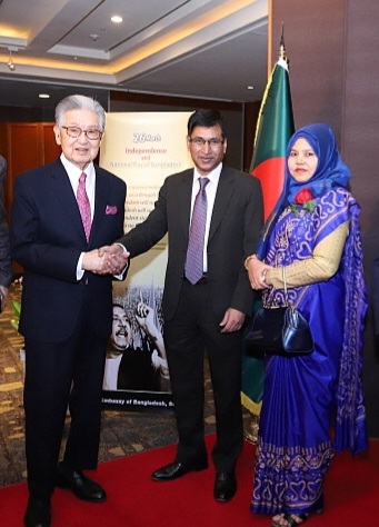 Ambassador Delwar Hossain of Bangladesh (center) shakes hands with noted Korean businessman, Tongsun Park (left). Mrs. Delwar Hossain is seen on the right.