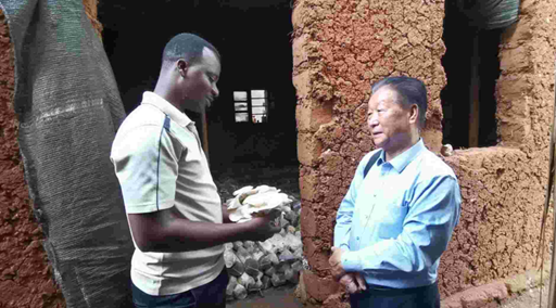 A photo took in 2019 shows Lin Zhanxi, who invented the Juncao Technology, instructs a local farmer in Rwanda to grow fungi. (Photo provided by Lin Zhanxi)