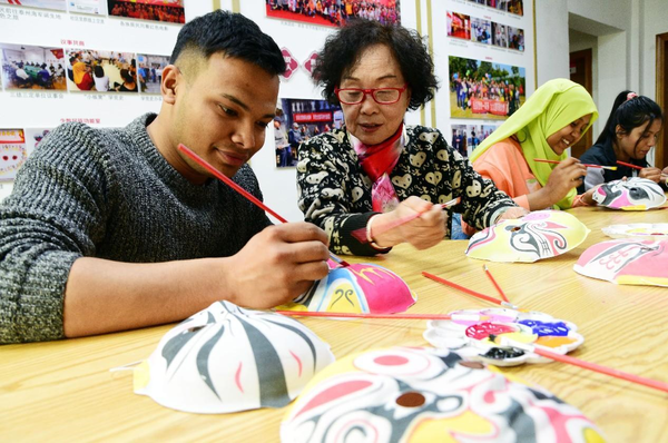 Foreign students of Jiangsu University of Science and Technology from Bangladesh, Morocco, Pakistan and Zambia learn to make Chinese opera masks under the instruction of local Chinese opera enthusiasts in Zhenjiang, east China's Jiangsu province, March 24, 2023. (Photo by Shi Yucheng/People's Daily Online)