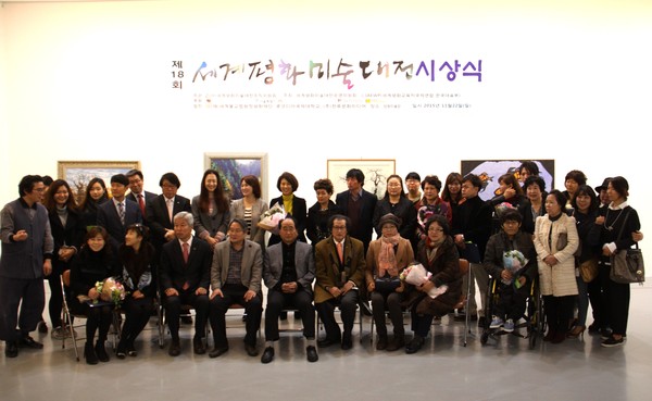 Chairman Lee Jon-young of Diplomacy Journal (seated third from left, front row) pose for the camera with the winners of prizes at the 2018 World Peace Art Exhibition.
