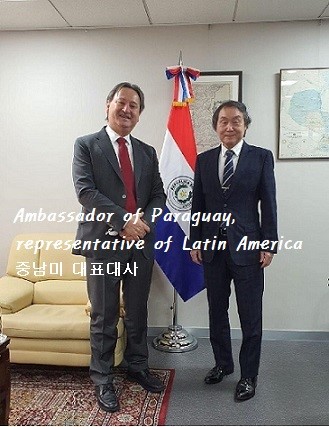 Ambassador Raul Silvero Silvagni of the Republic of Paraguay (left) poses with Chairman Shin Kwang-yul of the International Conference on Foreigners Welfare in front of the National Flag of Paraguay the Embassy of Paraguay in Seoul.