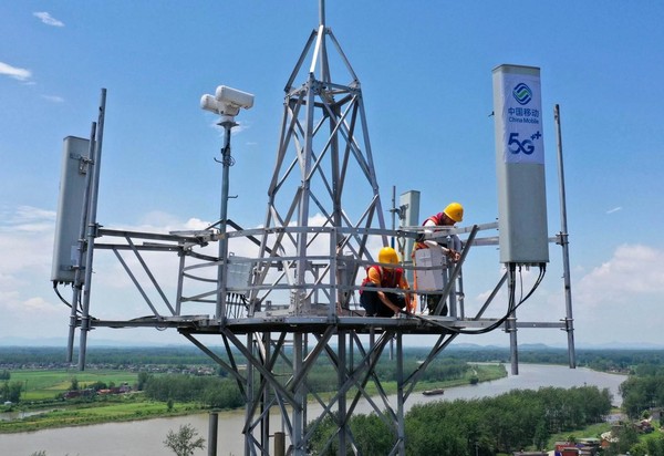 Workers adjust the antenna at a 5G base station in Tongling, east China's Anhui province. (Photo by Guo Shining/People's Daily Online)