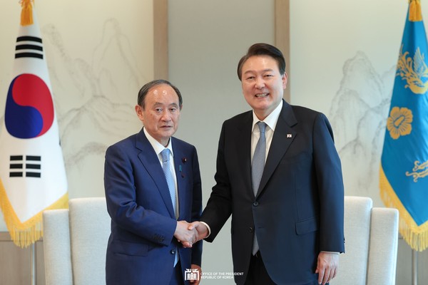 President Yoon Suk-yeol (right) shakes hands with former Prime Minister of Japan, Yoshihide Suga at the Office of the President in Seoul on May 31.