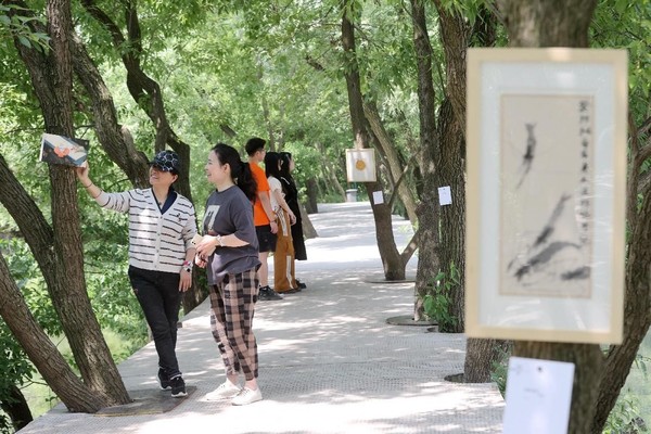 People visit an art exhibition held in Gaoqiao village, Deqing county, east China's Zhejiang province, May 13, 2023. (Photo by Xie Shangguo/People's Daily Online)