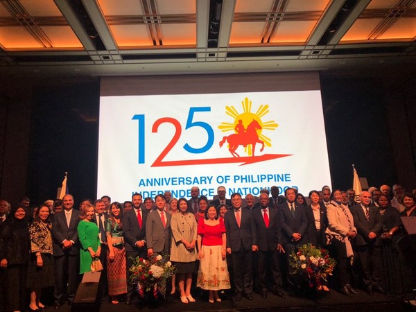 Deputy Foreign Minister Choi Youngsam of Korea is seen on the right of Ambassador Theresa Dizon De Vega of the Philippines clad in red upper-wear and pink skirts with the ambassadors and their spouses on the stage of the Regency Ballroom of the Grand Hyatt Seoul in celebration of the 12tth anniversary of Independence of the Philippines from Spain.