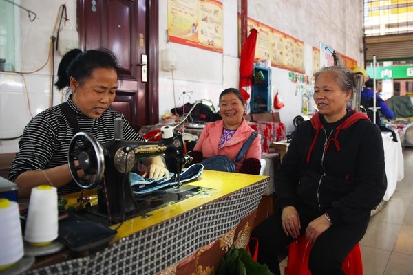 A tailor mends clothes for citizens in a market in Tongdao Dong autonomous county, central China's Hunan province, April 4, 2023. (Photo by Li Shangyin/People's Daily Online)
