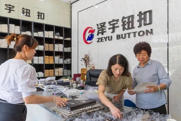 Employees sort buttons in a button shop in Qiaotou township, Yongjia county, Wenzhou, east China's Zhejiang province. (Photo from the official account of the information office of the government of Yongjia county)