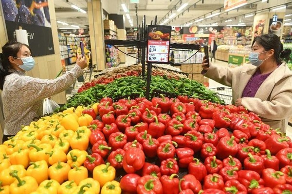 Citizens scan QR codes to learn information about vegetables in a supermarket in Yingdong district, Fuyang, east China's Anhui province. (Photo by Wang Biao/People's Daily Online)