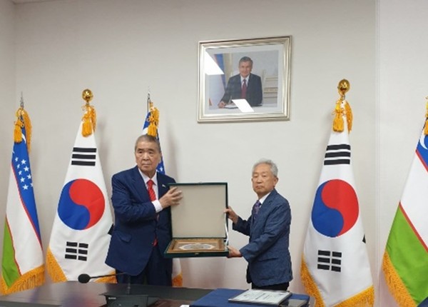Ambassador Vitaliy Fen of the Republic of Uzbekistan in Seoul (right) presents a Plaque of Certificate of Honor to Publisher-Chairman Lee Kyung-sik of The Korea Post media at the Embassy of Uzbekistan in Seoul. Vice Chairman Jang Chang-yong of The Korea Post (right) received the Citation on behalf of Publisher-Chairman Lee Kyung-sik of The Korea Post media who failed to attend the ceremony due to cold.