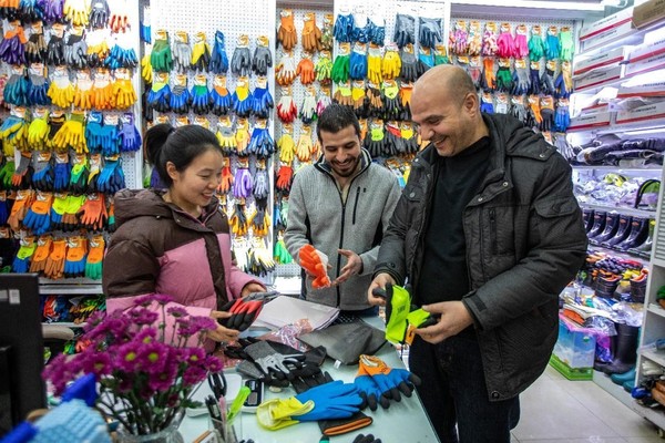 Foreigners buy commodities in a shop at the Yiwu International Trade Market, east China's Zhejiang province. (Photo by Yang Meiqing/People's Daily Online)