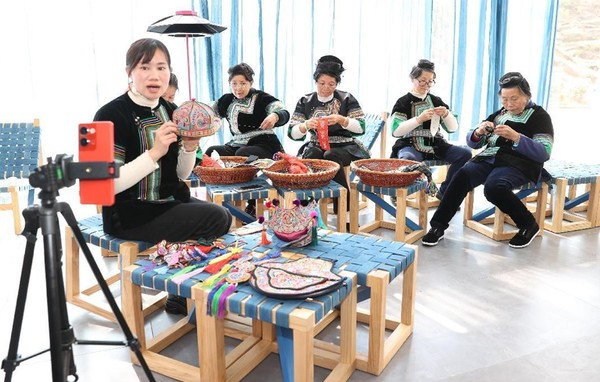 Women sell embroidery products via livestreaming in Rongjiang county, Qiandongnan Miao and Dong autonomous prefecture, southwest China's Guizhou province. (Photo by Zhang Kai/People's Daily Online)