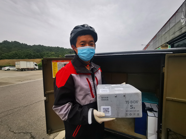 A deliveryman shows reusable packaging at an express delivery outlet of SF Express, a leading Chinese courier enterprise, in Beichuan Qiang autonomous county, southwest China's Sichuan province. (Photo from the media center of Beichuan Qiang autonomous county)