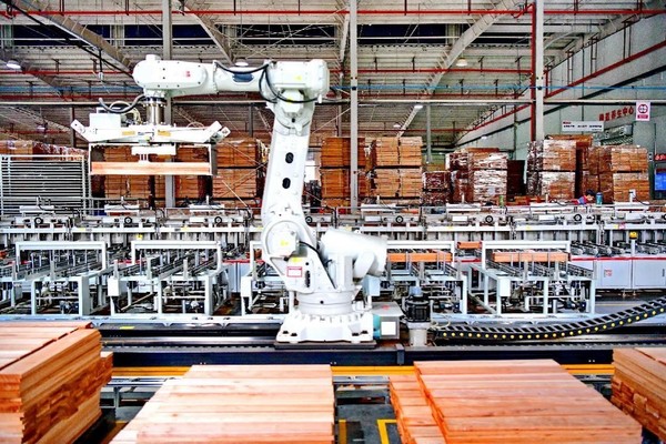 Wood floors are manufactured by a robotic arm in an intelligent workshop of an enterprise in Ganzhou, east China's Jiangxi province. (Photo by Zhu Haipeng/People's Daily Online)