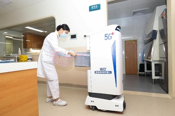 A nurse of the inpatient department of the Liuzhou Worker's Hospital, south China's Guangxi Zhuang autonomous region, takes out medicines from a logistics robot. (Photo by Chen Xinyuan)