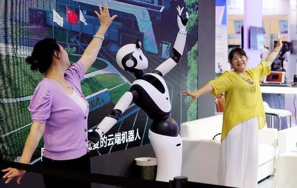 Citizens dance with a robot at the 2023 Global AI Product and Application Expo in Suzhou, east China's Jiangsu province, June 25, 2023. (Photo by Hua Xuegen/People's Daily)