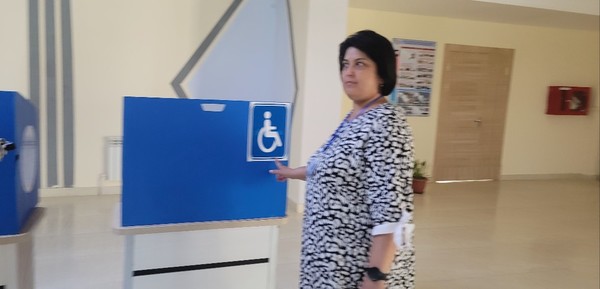 Mirmuhammedova Shahlo points to the accessible voting area for the disabled.