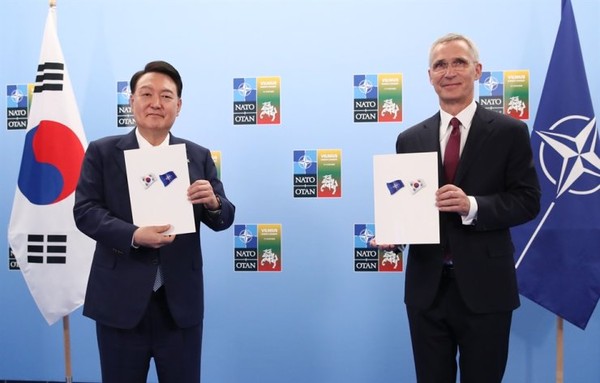 President Yoon Suk-yeol (left) and North Atlantic Treaty Organization Secretary-General Jens Stoltenberg show an agreement signed by the two sides during a meeting at the Lithuanian Exhibition and Congress Center in Vilnius, Lithuania, Tuesday (local time).