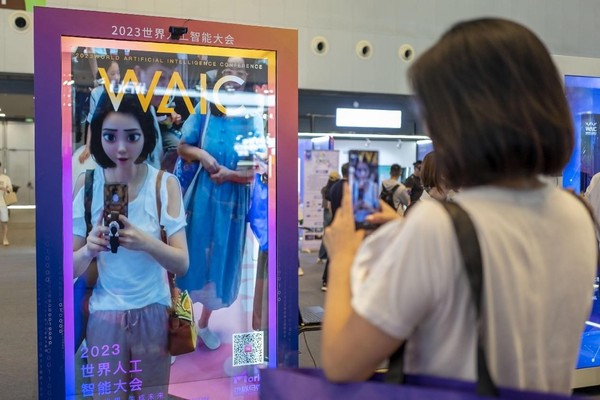 A woman takes photos of the cartoon image generated in real-time in front of an AI mirror at the 2023 World Artificial Intelligence Conference in Shanghai, July 6. (Photo by Wang Chu/People's Daily Online)