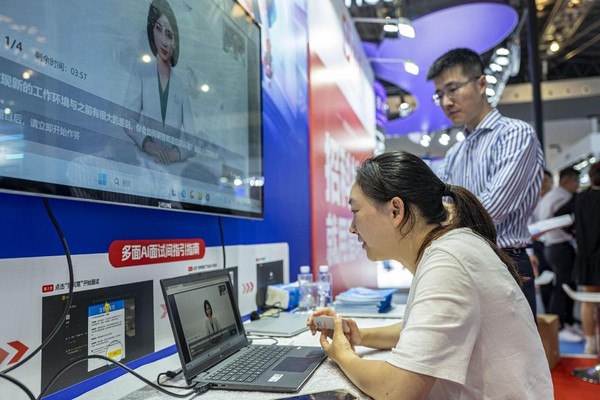 A woman experiences the AI job interview at the 2023 World Artificial Intelligence Conference in Shanghai, July 6. (Photo by Wang Chu/People's Daily Online)