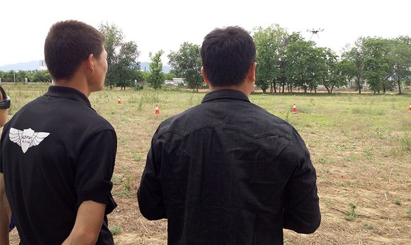 A coach instructs a trainee to control a drone. (Photo courtesy of the LTFY drone training school)