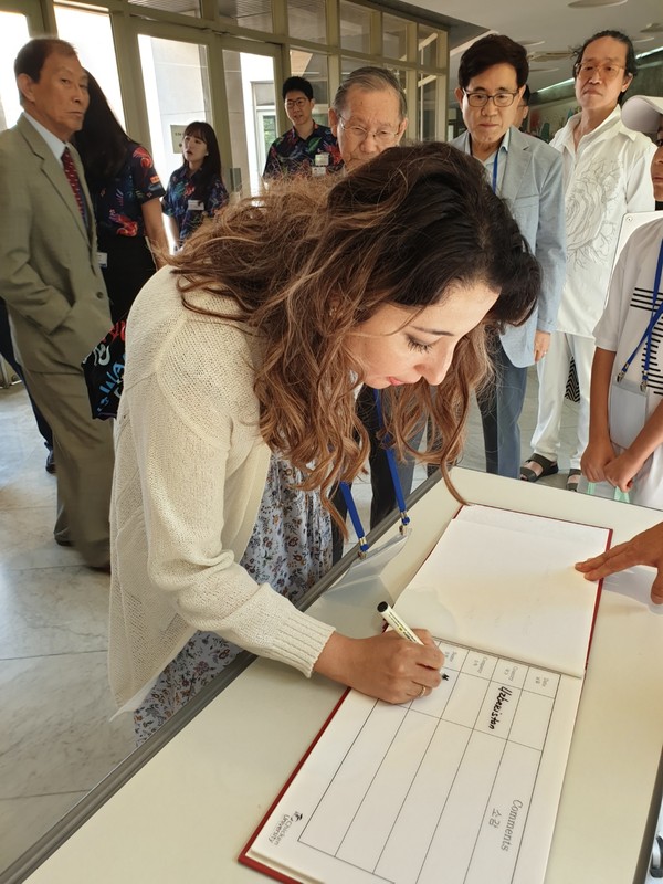 Mrs. Dilnoza Kurbanov, spouse of the 2nd secretary of Uzbekisan, signs her name in the Visitor’s Book