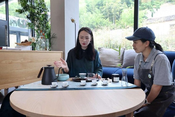 A B&B manager (right) learns tea ceremony from an instructor at Xiantan Art Gallery in Moganshan town, Deqing county, east China's Zhejiang province.(Photo by Xie Shangguo/ People's Daily Online)