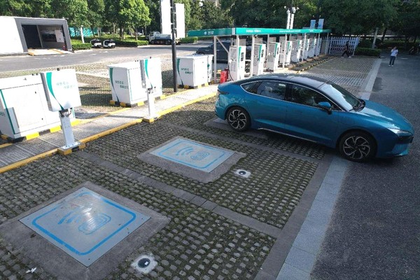 A new energy car is being charged through a wireless charging pad at a State Grid charging station in the Hangzhou Asian Games village in Xiaoshan district, Hangzhou city, capital of east China's Zhejiang province. (Photo by Long Wei/People's Daily Online)