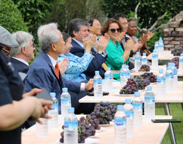 Ambassadors listening to the company's status and taste grapes raised without pollution.
