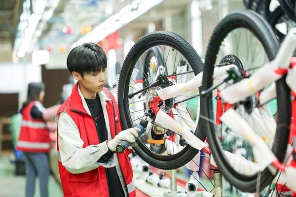 A worker of a bike manufacturing enterprise assembles a bike in Pingxiang county, Xingtai, north China's Hebei province. (Photo by Chai Gengli/People's Daily Online)