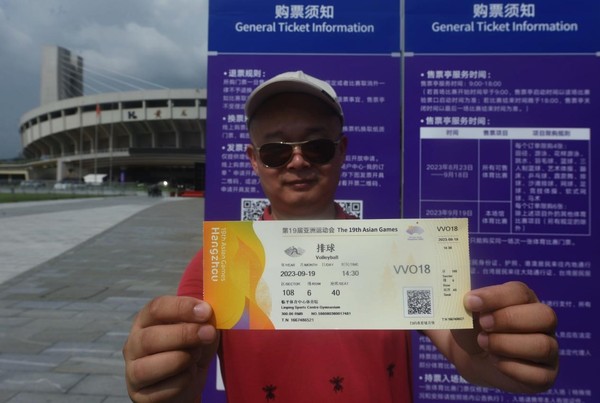 A spectator shows a volleyball ticket of the Hangzhou Asian Games he has just bought. (Photo by Long Wei/People's Daily Online)