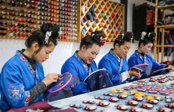 Embroiderers work in Long Luying's workshop. (Photo by Mo Guibin/People's Daily Online)