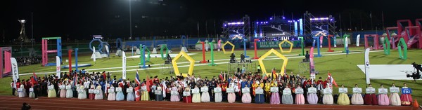 Ladies stand in front of show holding placards with the names of the participating teams from many countries of the world as well as from within Korea.