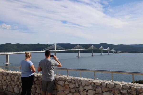 Tourists take photos of the China-constructed Peljesac Bridge in southern Croatia (Photo by Liu Zhonghua/People's Daily)