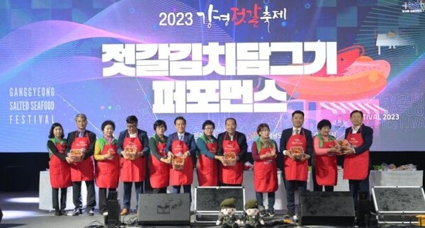 Officials and event staff members of Ganggyeong Jeotgal Festival gather hands on the stage for "Jeotgal Kimchi in the Making" performance.