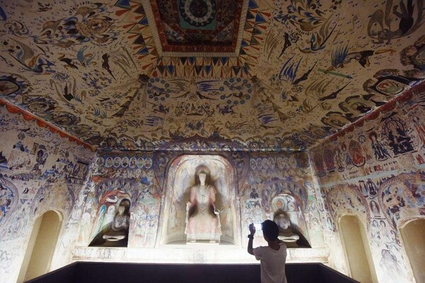 A man visits a 1:1 replica of the Cave 285 of the Mogao Grottoes at the China National Silk Museum in Hangzhou, east China's Zhejiang province, July 18, 2023. (Photo by Long Wei/People's Daily Online)