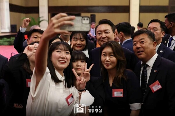 President Yoon Suk-Yeol on Nov. 11, 2023 takes a selfie with Korean residents of Cambodia at an event held at Sokha Hotel Phnom Penh in the capital. He thanked the residents for playing a major role in forming the friendly ties between both countries and pledged to do his best "to make a Republic of Korea everyone can be proud of."