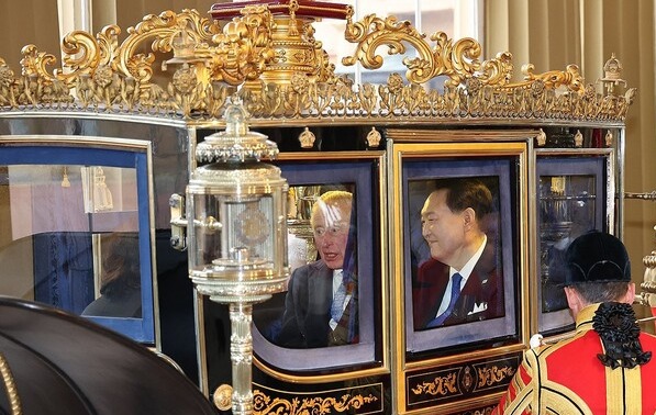 South Korean President Yoon Suk Yeol (R) and King Charles III riding in a horse-drawn carriage arrive at Buckingham Palace after they attended a welcome ceremony for the South Korean leader at Horse Guards Parade in London on Nov. 21, 2023, during his state visit to Britain to celebrate 140 years of diplomatic relations.