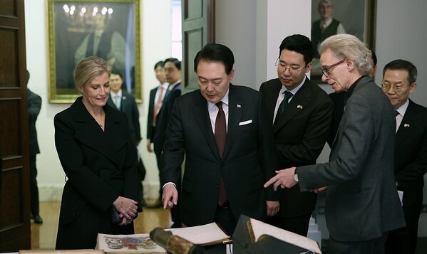South Korean President Yoon Suk Yeol (C) looks at an exhibition at the Royal Society, Britain's national academy of sciences, in London on Nov. 22, 2023. 