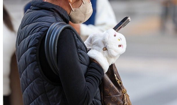 People are dressed in warm clothing and gloves to counter the cold weather, in which temperatures dropped to below the freezing point on Nov. 20, 2023.