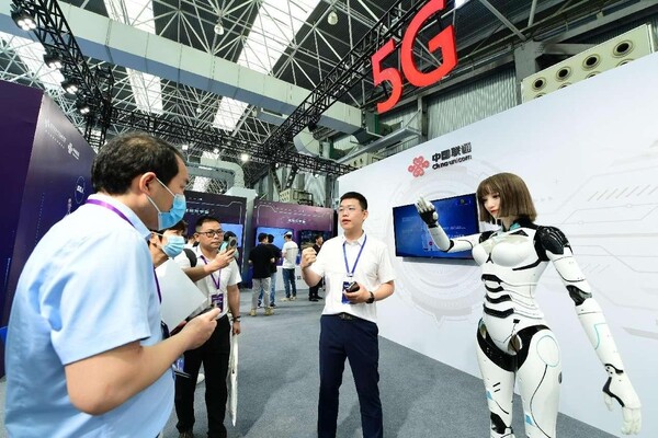 Visitors interact with a humanoid robot at the Kunshan Metaverse International Equipment Exhibition held in east China's Jiangsu province, June 27, 2023. (Photo by Ji Haixin/People's Daily Online)